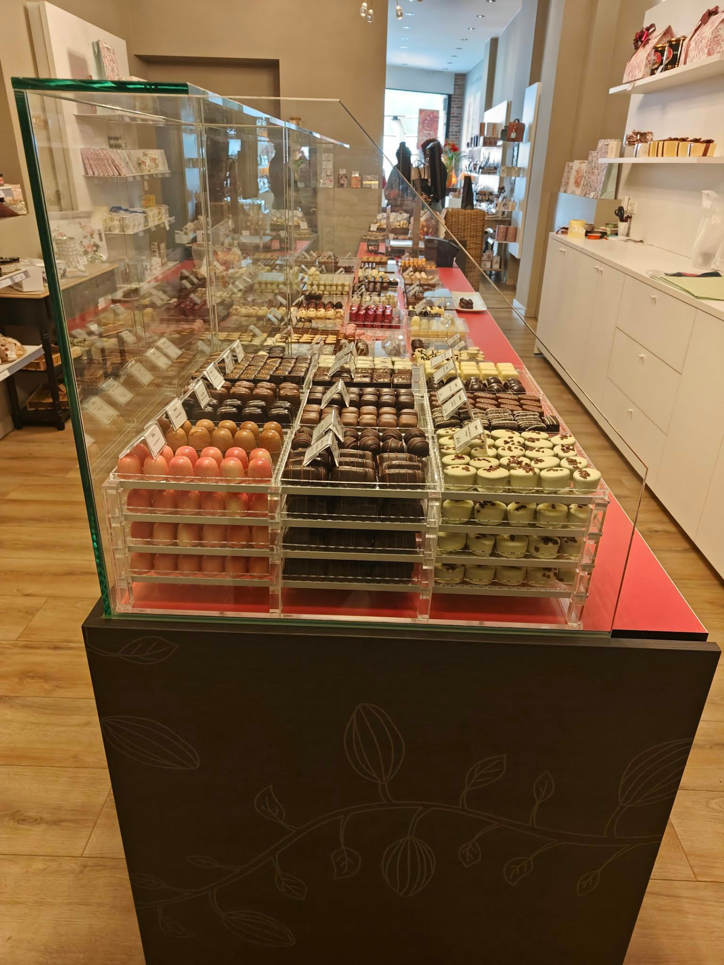 Glazen toonbankvitrine met pralines in gestapelde acrylaatbakjes